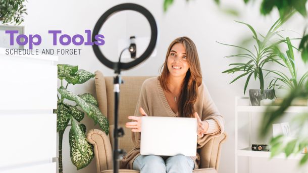 Influencer using a laptop to schedule social media posts with a ring light and phone tripod nearby.