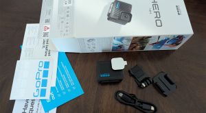 A small, black GoPro Hero 4K action camera resting on a table, its compact size and potential for discreet use.